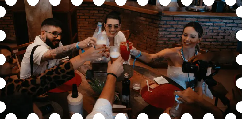 Participantes do BrEx brindando com drinques em confraternização à mesa, em Ilhabela